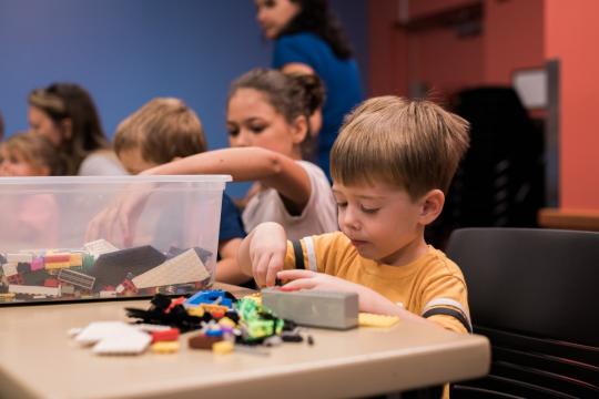 A group of children at a table playing with LEGO