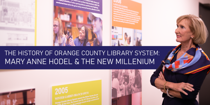 Mary Anne Hodel looking at panels on wall depicting the library's history.