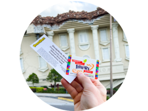 Circle image of a hand holding a library card and WonderWorks Orlando Ticket