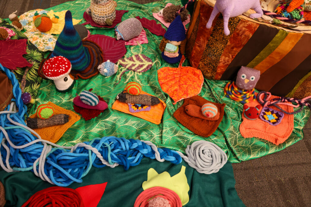 Various items created from yarn and fabric for an enchanted forest themed art installation.