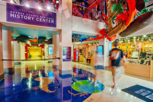 Interior lobby of the Orange County Regional History Center featuring colorful art displays leading into the exhibit halls.