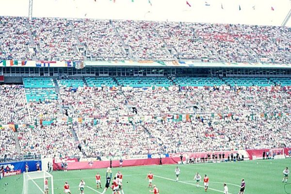 A photo from 1994 featuring a large stadium filled to capacity. A soccer field and soccer players can be seen below.