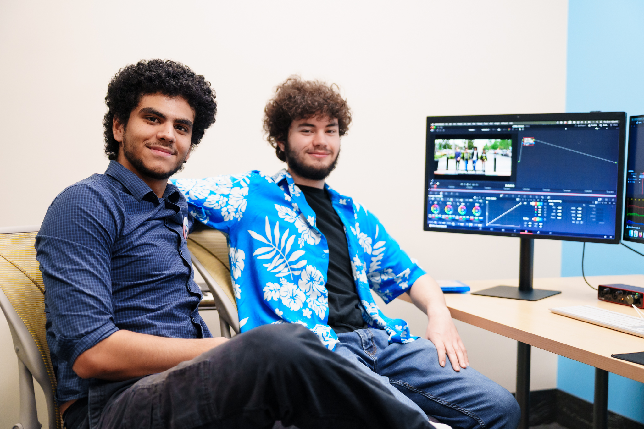 Photo of Charlie Batista and Sabian Orazi sitting at one of the video editing bays in the Melrose Center.