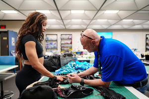 Breanna Covington works with OCLS sewing instructor Michael Sweeney in the sewing studio